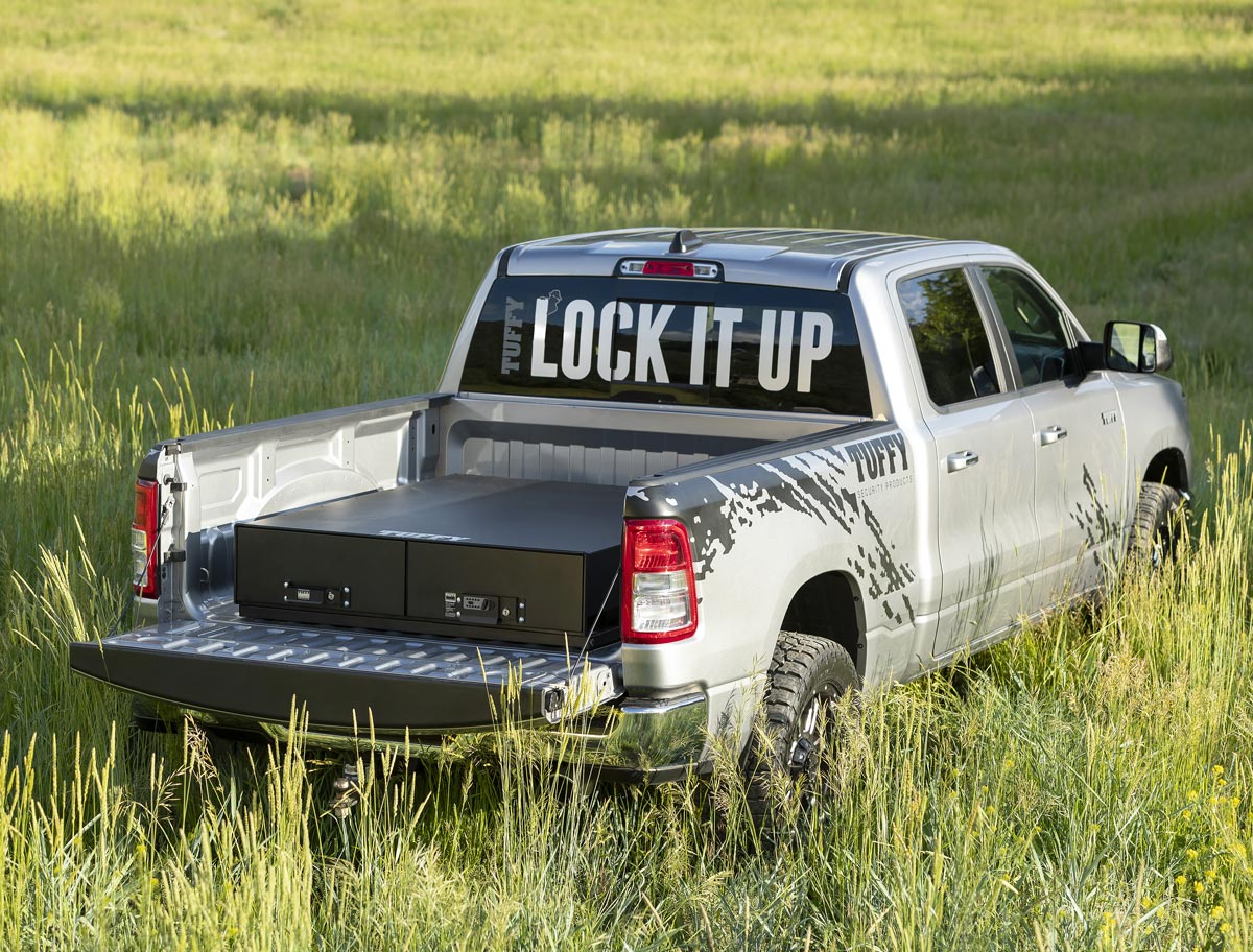 Tuffy security in tall grass field with lock box on the bed of the truck