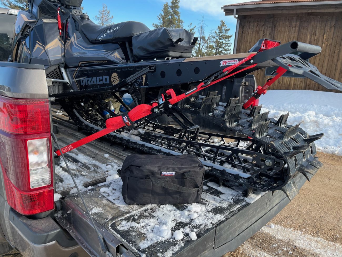 Red Ratchet Strap tie-down used to tie down a Snowmobile in a truck bed