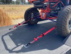 Red Ratchet Strap tie-down with a Tied down UTV on a trailer
