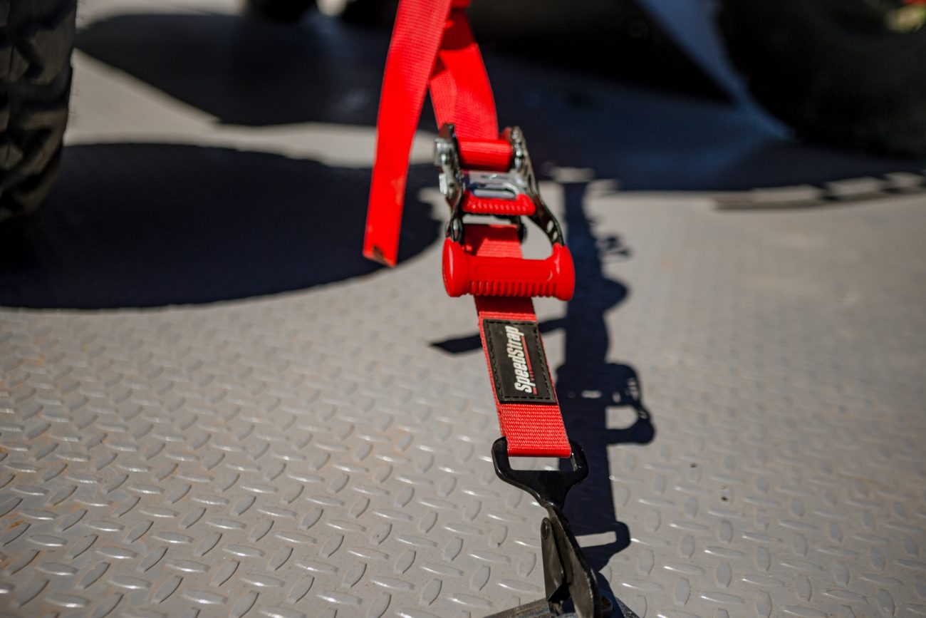 Red Ratchet Strap tie-down with a tied down on a trailer
