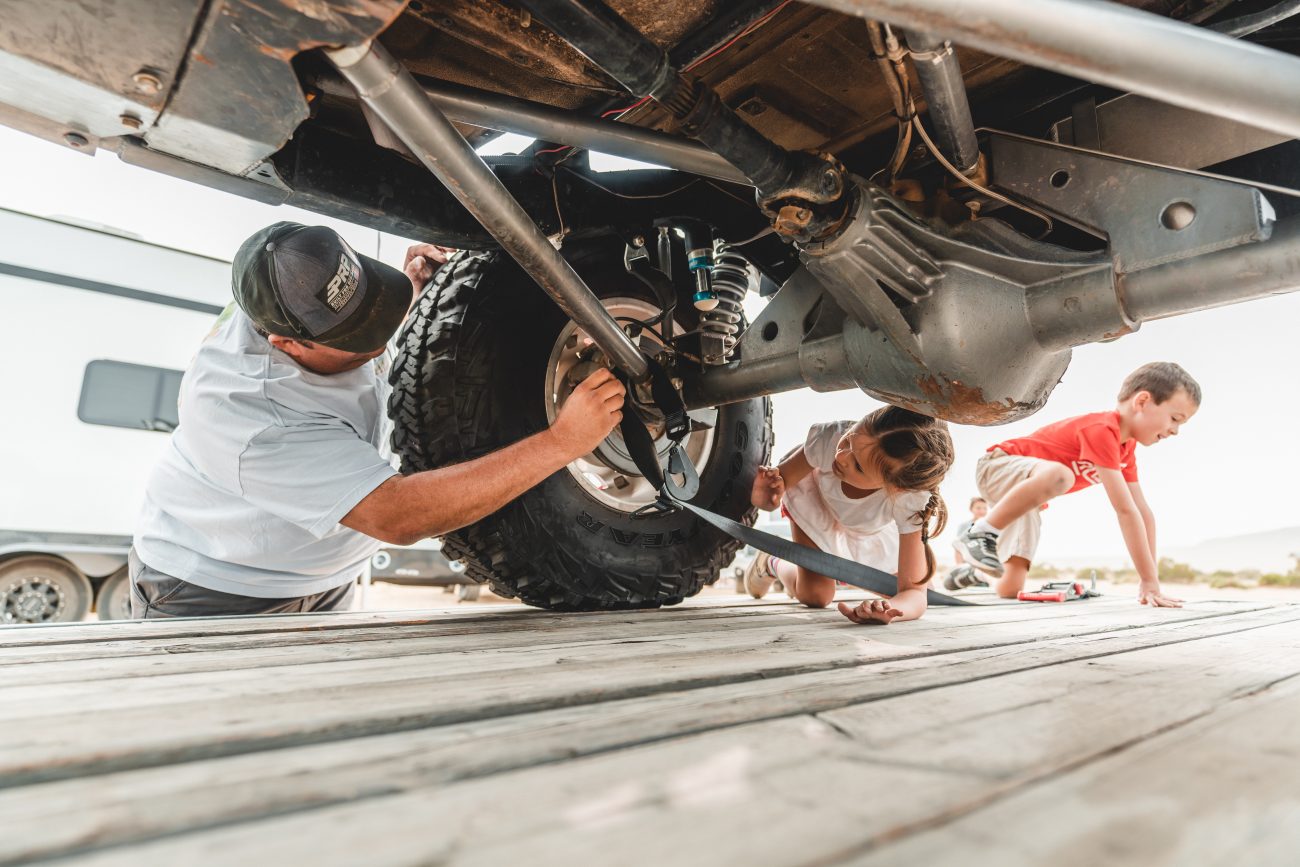 Man shows kids how to use an axle strap properly before transport